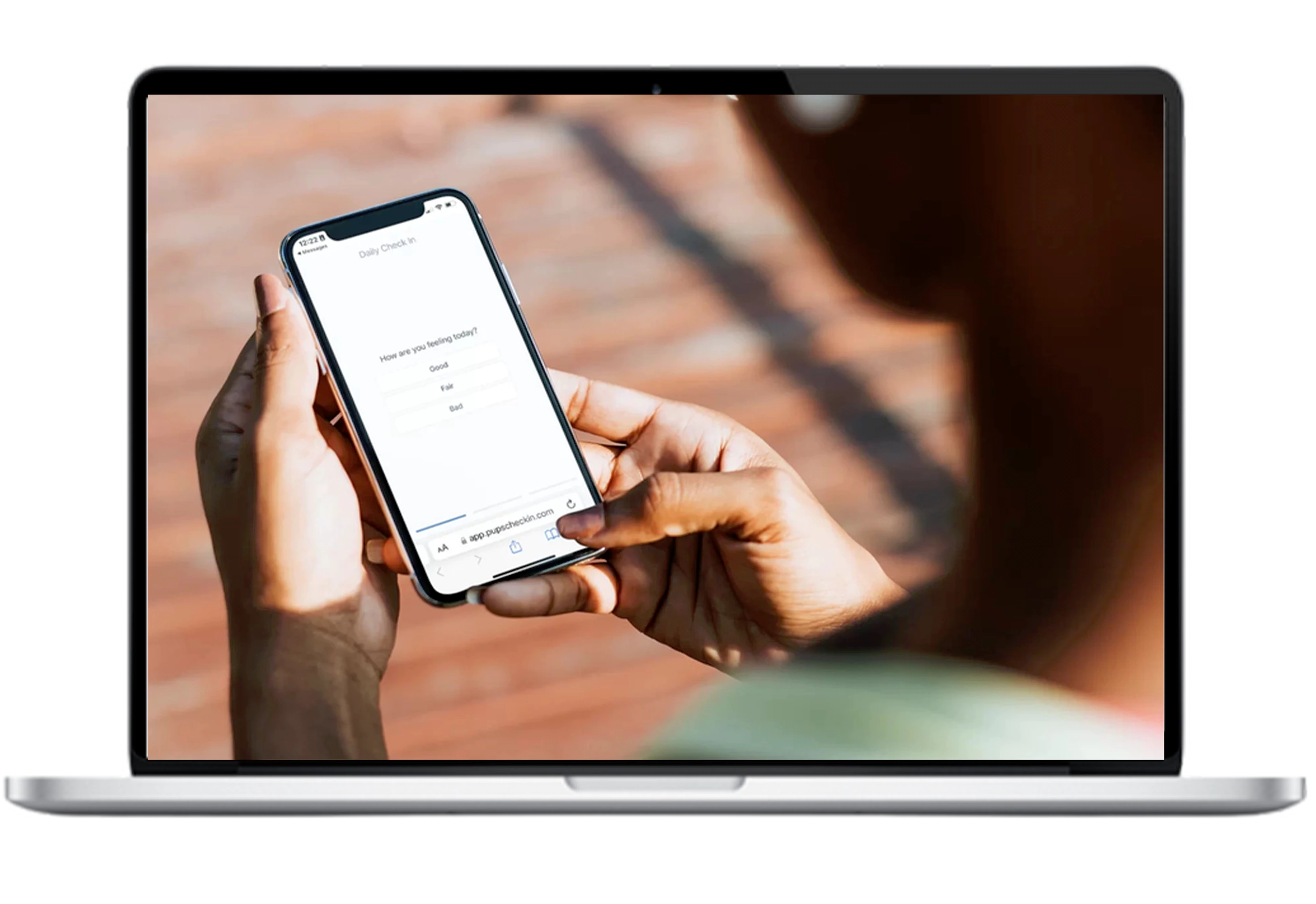 A person answering a daily check in question on a mobile phone on laptop screen
