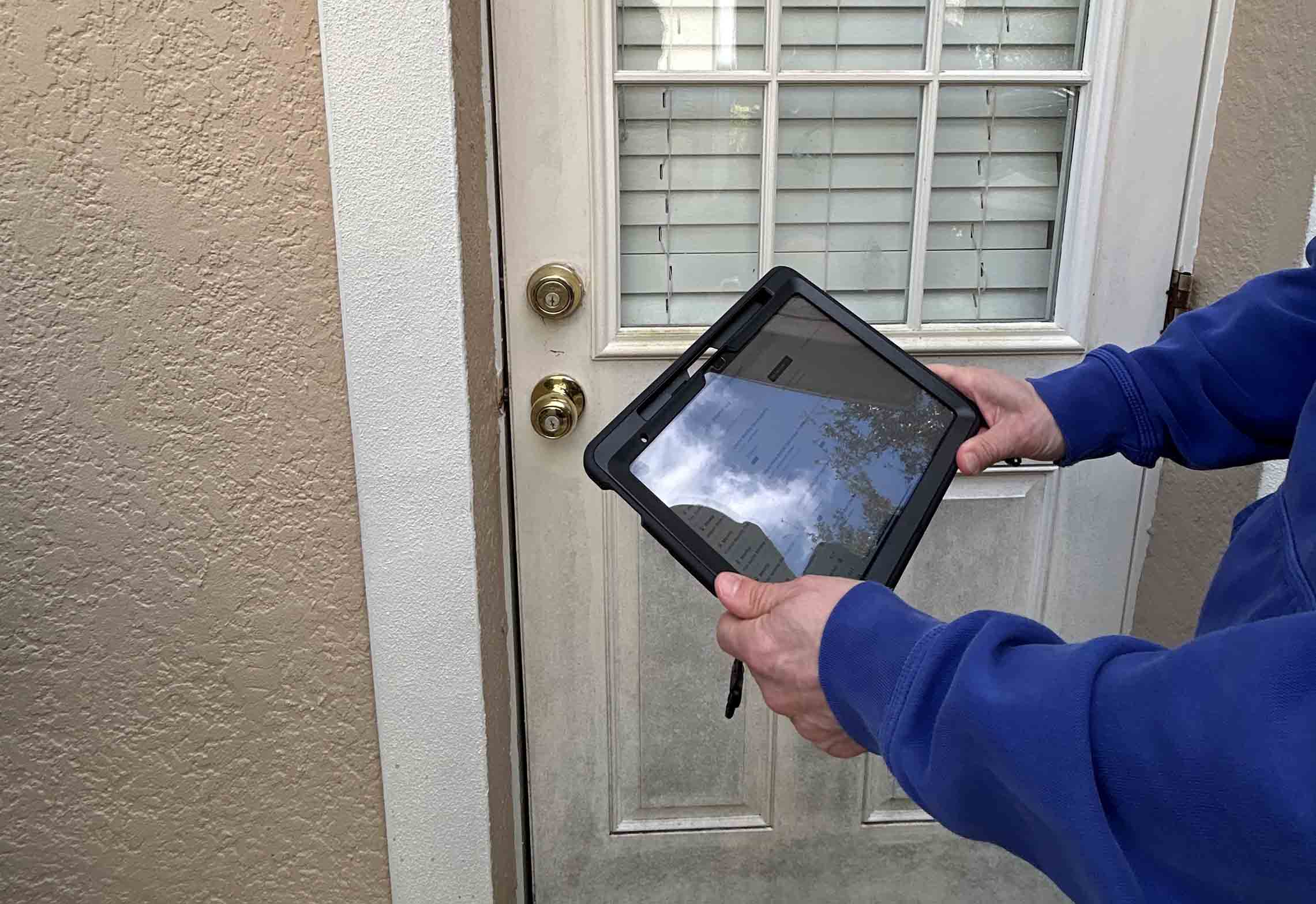 A person conducting an inspection while holding a tablet