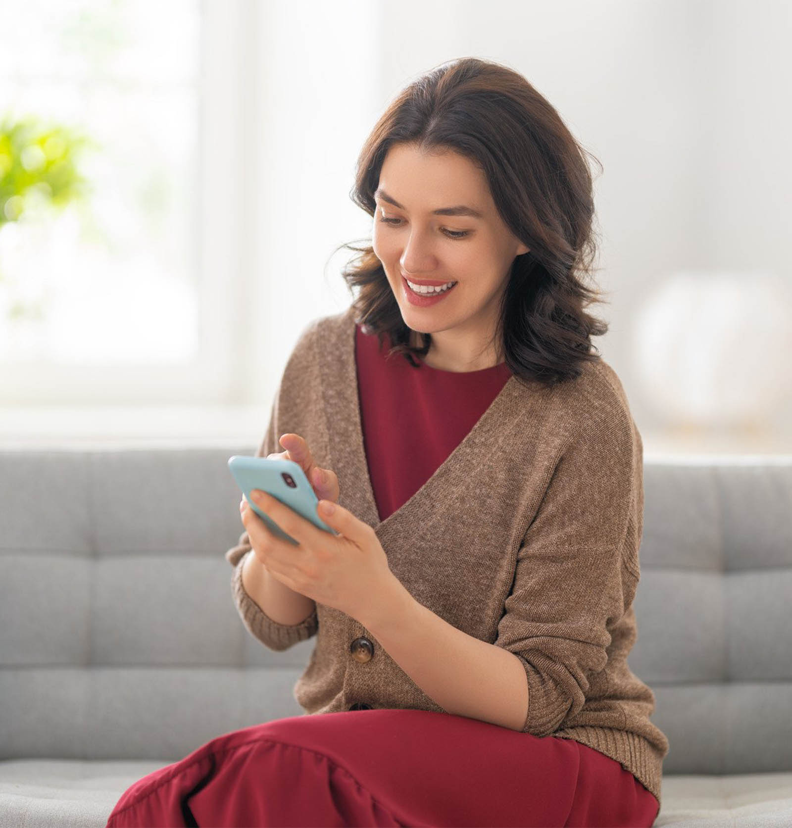 Woman on a couch using a mobile phone